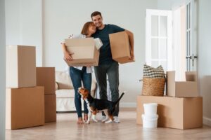 Ett par som håller flyttkartonger