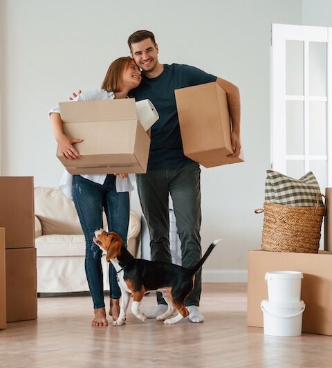 Ett par som håller flyttkartonger